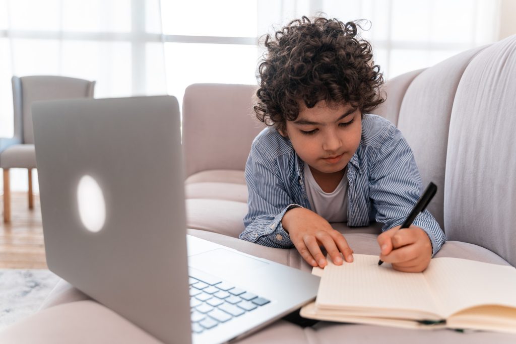 little kid studying on his laptop